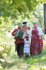 A group of people in Russian folk costumes walking around a beautiful village