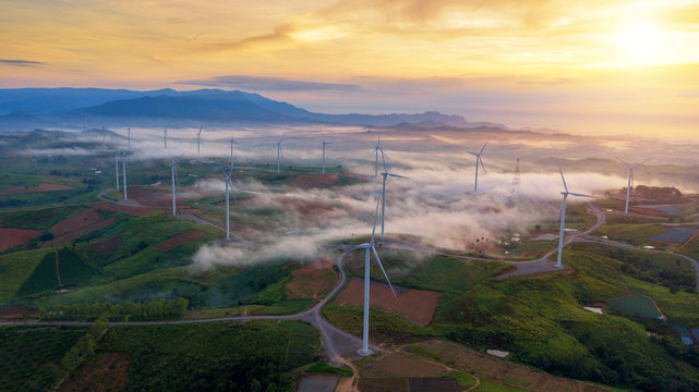 Green Energy Wind Turbine, Aerial view sunrise from Drone flying Wind turbines produce electricity natural energy.