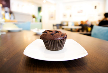 Chocolate muffin on the wooden table in coffee shop..