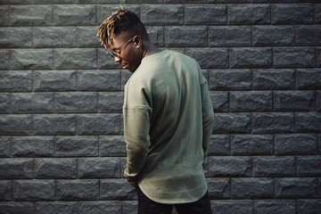 Obraz premium Man wearing fashionable pullover clothes against brick wall background