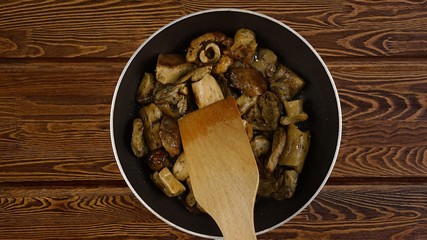 Cooking food concept. The cook fry the mushrooms in a frying pan.