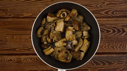 Cooking food concept. The cook fry the mushrooms in a frying pan.