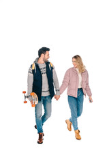 beautiful happy young couple holding hands and walking together, man holding skateboard isolated on white
