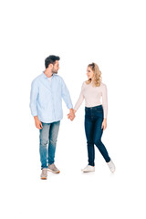 Fototapeta premium full length view of happy young couple holding hands and smiling each other isolated on white