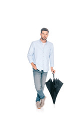 Fototapeta premium handsome man holding black umbrella and looking at camera isolated on white