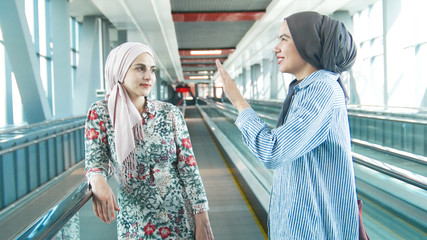 Two muslim girls walk around the airport