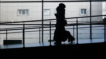 Two muslim girls silhouette walking by the panoramic window background