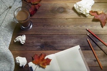 Autumn and fall background, note book and paper, maple leaves and cocoa drink. Top view, space for text.