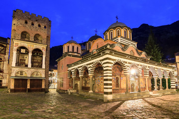Fototapeta na wymiar Beautiful view of the Orthodox Rila Monastery, a famous tourist attraction and cultural heritage monument in the Rila Nature Park mountains in Bulgaria in the blue hour at night
