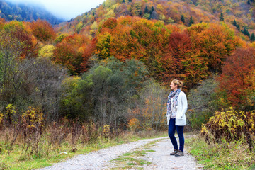 Beautiful young woman hikes in the forest in the mountains of the Rila Nature Park in Bulgaria with...