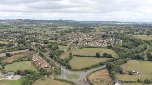 Aerial view, zoom out move. Tarvin, small town in cheshire. Plains, fields and grassland.