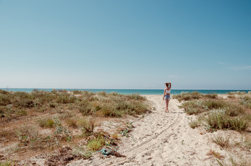 The young beautiful woman is walking along the seaside