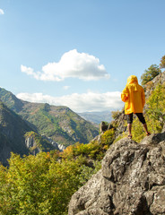 Obraz premium A man is standing on a rock and looking at the mountains
