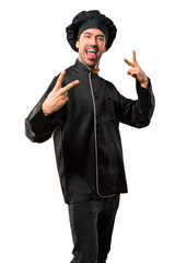 Chef man In black uniform showing tongue at the camera having funny look on isolated white background