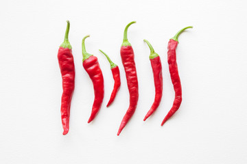 Beautiful red hot chili peppers on white table. Flat lay. Top view.