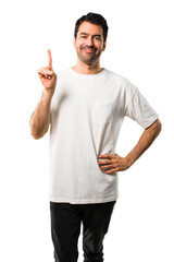 Young man with white shirt showing and lifting a finger in sign of the best on isolated white background