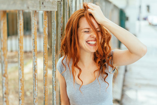 Woman with hair and grey shirt pulling her hair