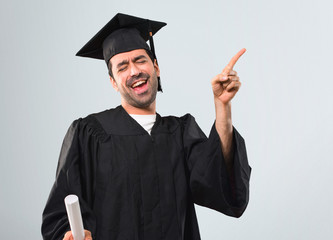 Man on his graduation day University enjoy dancing while listening to music at a party on grey...