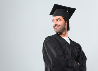 Man on his graduation day University in lateral position while looking over the shoulder with a...