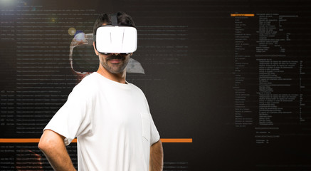 Naklejka premium Man using VR glasses posing with arms at hip inside the virtual reality mode