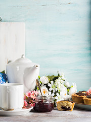 Breakfast table setting with white crockery and flowers