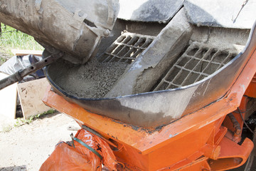 close up view of the flowing concrete from concrete mixer machine to the pump