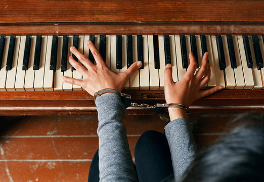 Female Hands In Chains On A Piano