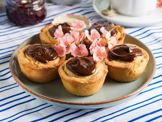 Cakes with frangipane, cherry jam and chocolate frosting. Romantic table setting with flowers. Mother's day card