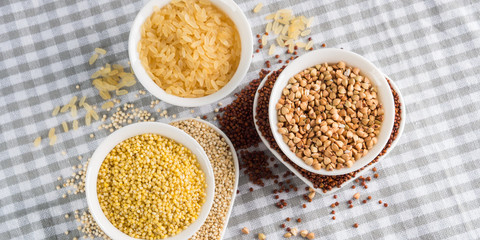 Gluten free grains quinoa, rice, buckwheat, amaranth, millet in bowls on kitchen table. Celiac diet