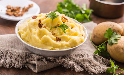 Mashed potatoes in bowl decorated with parsley herbs.