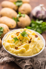 Mashed potatoes in bowl decorated with parsley herbs.
