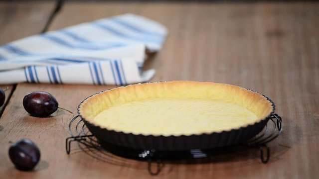 Baked Pie Base Pastry made orr Pie or Tart or Cake Dessert from. Dough in tart Pan. Making a cake with plums