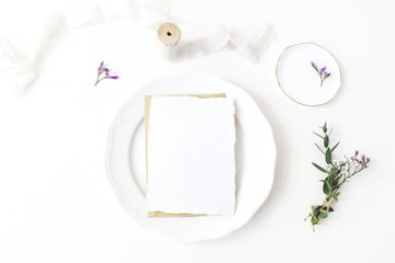 Festive wedding, birthday table setting with porcelain plate, silk ribbons and floral bouquet of eucalyptus, limonium flowers. Blank card mockup. Rustic restaurant menu concept. Flat lay, top view