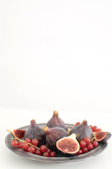 Ripe organic red currant Figs Ceramic plate Isolated white background background Still life Copy space Autumn harvest