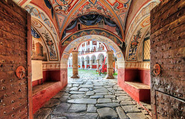 Beautiful view of the entrance gate at the Orthodox Rila Monastery, a famous tourist attraction and cultural heritage monument in the Rila Nature Park mountains in Bulgaria - 224138472