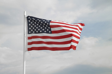American flag on a blue sky with clouds background