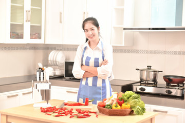 Asian housekeeper smiles in modern kitchen