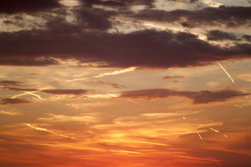 beautiful view of the sunset sky orange with clouds and condensation traces