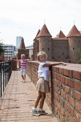 Outdoor portrait of young beautiful boy and girl posing on old street. Old Warsaw, Poland, summer