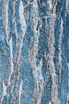 Inverted image of a Ponderosa pine tree bark, close up of ridges and growth patterns. Blue and silver colours. 