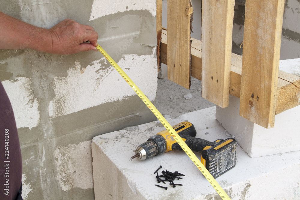 Poster close up view of the hand holding the measuring tape next to the foam block. the customer measures t