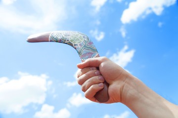 Wooden Boomerang with Blue Sky and Cloud Background