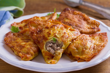 Savory stuffed crepes with meat. Pancakes filled with meat