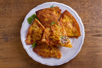 Savory stuffed crepes with meat. Pancakes filled with meat. View from above, top studio shot