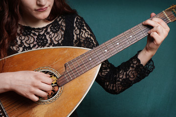 close-up of female hands playing old vintage lute string instrument