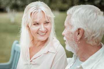 Watching you. Pretty blonde keeping smile on her face while enjoying pleasant communication