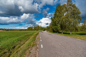 Fototapeta na wymiar a road and a cloudy sky in storfors sweden