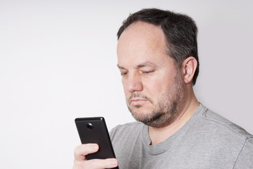 middle aged man looking down at his mobile smart phone                              