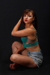 Fototapeta premium portrait of a young girl in sexy lingerie and shorts