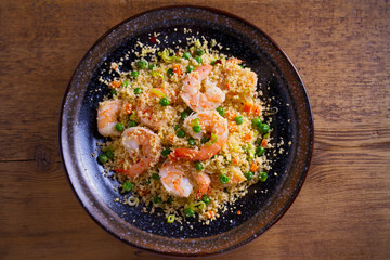 Shrimps with couscous, green peas, leeks and carrot. overhead, horizontal
